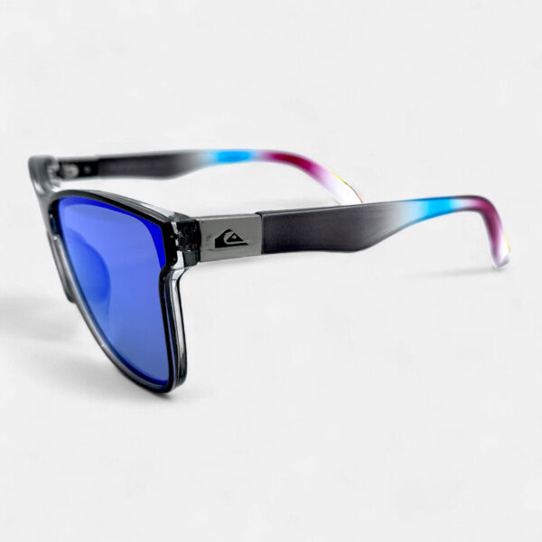 Left side view of the Quiksilver 'Ombre' Square sunglasses, featuring the profile of the translucent gray ombre frame and the blue mirror lens.