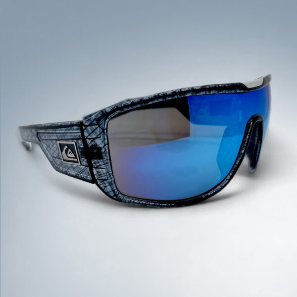 Composite image showing the front and side view of the Quiksilver QS233 Polarized Sport Wrap Shield sunglasses, highlighting the crosshatch textured frame and the large green-blue mirror lens on the right side.