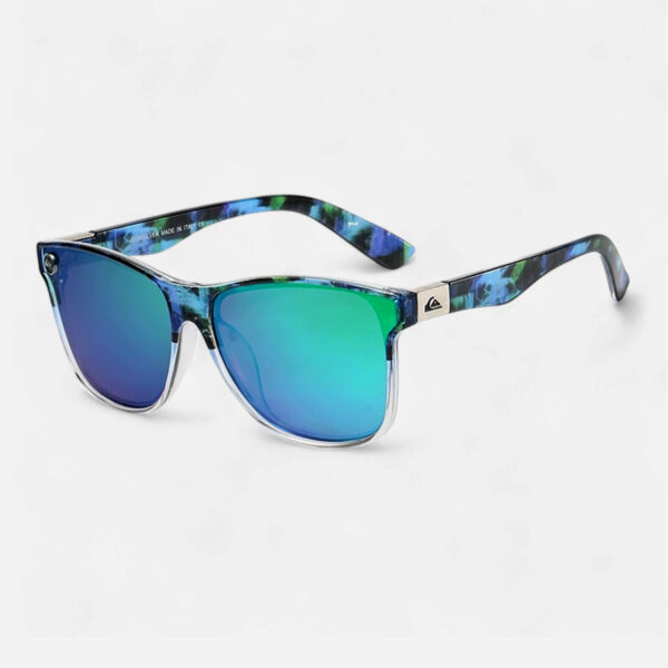 Angled view of the Quiksilver 'Hydro-Camo' Square sunglasses, showcasing the clear, translucent frame and the distinctive ombre blue mirror lens that fades from dark to light blue.